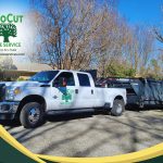 Lake Fork News A ProCut Tree Services work truck, prominently displaying the company's logo and contact information, is parked along a quiet residential street in East Texas. The vehicle is attached to a substantial covered Lamar trailer, poised for tree removal or landscaping work. In the sunlit background, bare branches of leafless trees frame single-family homes typical of this East Texas neighborhood, capturing a crisp but clear day in the region. Lake Fork, TX